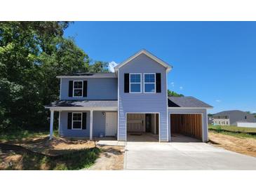 Charming two-story home boasts a covered front porch and an attached two-car garage, perfect for any Gathering at 2554 Whitetail Rd, Nashville, NC 27856
