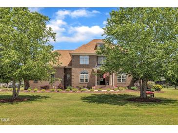 Charming two-story brick home with a well-manicured lawn, mature trees, and an inviting front porch at 296 Shoreline Dr, Princeton, NC 27569