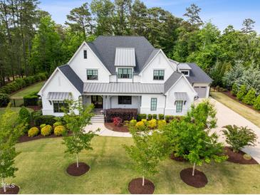 Stunning two-story home with professional landscaping, gray roof, and a welcoming covered front porch at 5125 Avalaire Oaks Dr, Raleigh, NC 27614