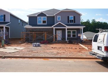 New two story home under construction showing garage, blue siding, and covered porch at 729 Deschutes Dr, Garner, NC 27529