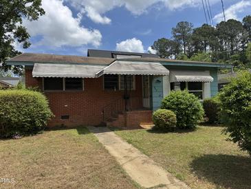 Charming one-story home with brick facade, awnings, and a small front yard at 829 Coleman St, Raleigh, NC 27610