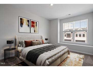 Bright bedroom with a cozy bed, stylish decorations, and a large window with blinds at 1018 Westerland Way # 204, Durham, NC 27703