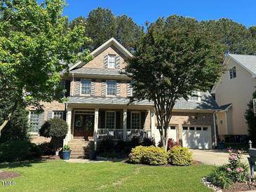 Charming two-story brick home featuring a well-manicured lawn and inviting front porch at 1021 Golden Star Way, Wake Forest, NC 27587