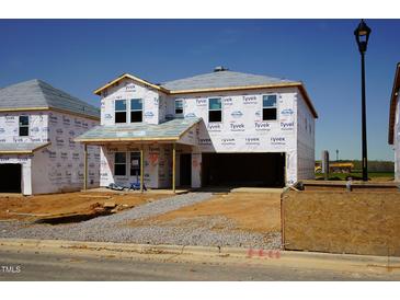 Unfinished two-story home exterior with a two-car garage and covered porch, showcasing its potential at 1116 Landen Creek Ln, Zebulon, NC 27597