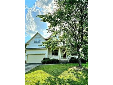 Charming two-story home features a front porch, two-car garage, and a well-maintained lawn with mature landscaping at 120 Hatchet Creek Ct Ct, Morrisville, NC 27560