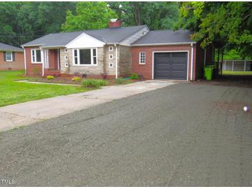 Charming single-story brick home with a well-maintained lawn and a paved driveway at 1610 W B St, Butner, NC 27509