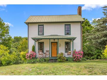 Charming two-story home with a quaint front porch, rocking chairs, porch swing and beautiful landscaping at 2440 Glencoe St, Burlington, NC 27217