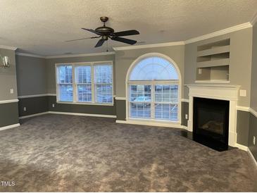 Spacious living room with modern fireplace, large windows, and stylish ceiling fan at 3489 Forestdale Dr # 2D, Burlington, NC 27215