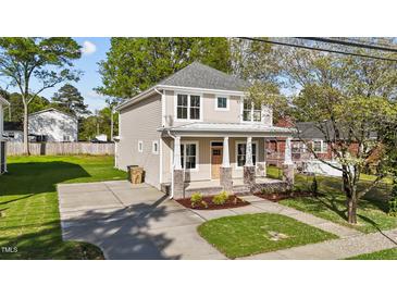 Charming two-story home featuring a welcoming front porch, fresh landscaping, and a well-manicured lawn at 408 W Stallings St, Clayton, NC 27520