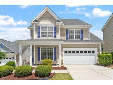 Charming two-story home with blue shutters, manicured landscaping, and an attached two-car garage at 4509 Joe Cotton Dr, Knightdale, NC 27545