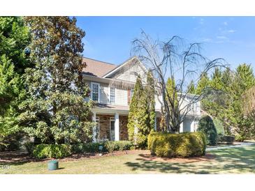 Charming two-story home with stone accents, covered porch, and professionally landscaped yard at 7516 Orchard Crest Ct, Apex, NC 27539