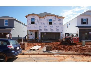 New two-story home under construction with Tyvek wrap and Bobcat machinery at 813 Ottawa Dr, Garner, NC 27529