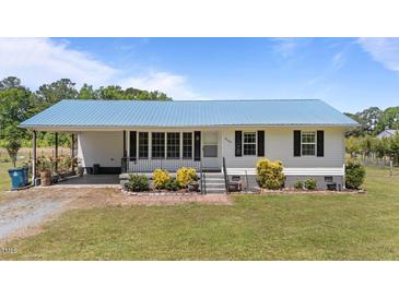 Charming single-story home featuring a metal roof, covered porch, and well-manicured lawn at 8163 Julian Rd, Dunn, NC 28334