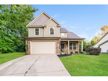 Charming two-story home features a two-car garage and manicured front lawn at 124 Owensboro Ct, Raleigh, NC 27603