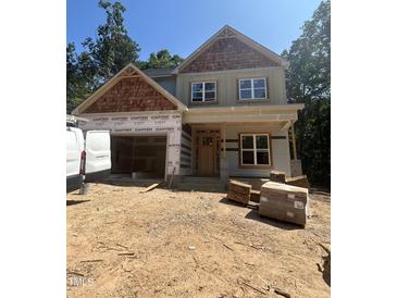 New construction home featuring a two-car garage, covered front porch, and wood and light-green siding at 188 Landon Ridge, Sanford, NC 27330