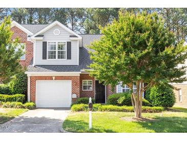 Charming brick home with a well-manicured lawn, attached garage, and lush landscaping at 2089 White Pond Ct, Apex, NC 27523