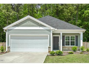 Charming single-story home featuring a two-car garage, manicured lawn, and stone-accented facade at 230 Forest Meadow Ln, Franklinton, NC 27525