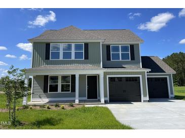 Charming two-story home with a manicured lawn, black shutters and a two-car garage at 253 Lotus Ave, Smithfield, NC 27577