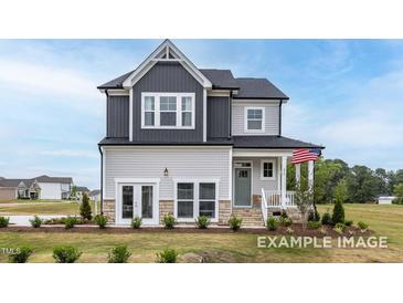 Charming two-story home with a mix of gray and white siding, a cozy front porch, and a well-manicured lawn at 420 Longleaf Glen Ln, Zebulon, NC 27597