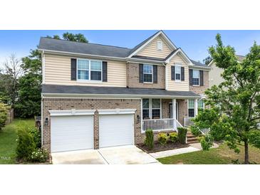 Charming two-story home features a two-car garage and a cozy front porch, complemented by manicured landscaping at 513 Heswall Ct, Rolesville, NC 27571