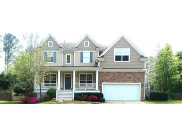 Charming two-story home featuring blue shutters, a covered porch, and an attached two-car garage at 704 Valleywater St, Fuquay Varina, NC 27526
