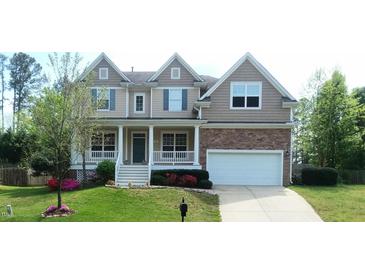 Charming two-story home featuring a welcoming front porch, beautiful landscaping, and a two-car garage at 704 Valleywater St, Fuquay Varina, NC 27526