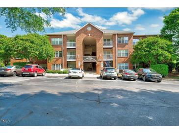 Brick apartment building with multiple balconies and parking spaces in front at 107 Sturbridge Dr, Clayton, NC 27520