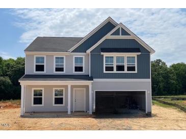 Charming two-story home with a two-car garage and light-grey and dark-blue siding at 129 Sagamore Avenue, Angier, NC 27501