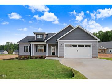 Charming new construction home featuring a gray color scheme, landscaped yard, and attached two-car garage at 157 Gumtop Dr, Zebulon, NC 27597