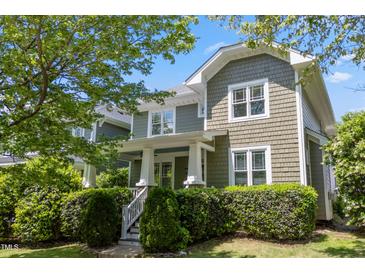 Charming two-story home featuring a shake shingle exterior, white trim, and a well-manicured landscaped front yard at 2121 Karns Pl, Raleigh, NC 27614