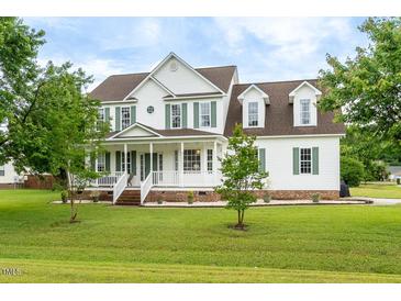 Charming two-story home with a welcoming front porch and beautifully landscaped front yard at 31 Bucking Saddle Way, Willow Springs, NC 27592