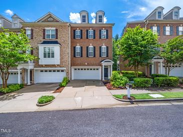 Three-story brick townhome with two dormer windows above the attached two-car garage at 312 Bridgegate Dr, Cary, NC 27519