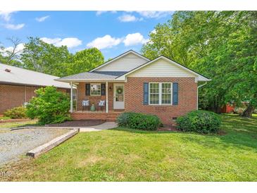 Charming brick home with a cozy front porch and a well-manicured lawn at 34 Johnston St, Pittsboro, NC 27312