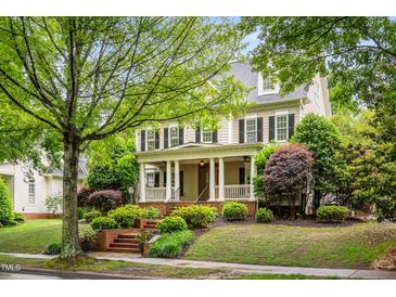 Inviting two-story home featuring a charming front porch and professionally landscaped yard at 3821 Falls River Ave, Raleigh, NC 27614