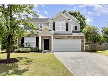 Charming two-story home with stone accents, a well-maintained lawn, and a spacious two-car garage at 430 Dogwood Creek Pl, Fuquay Varina, NC 27526