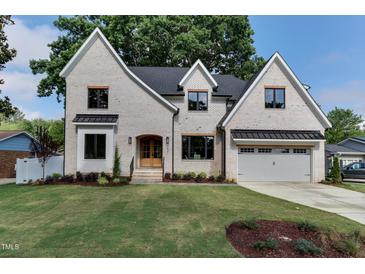 Charming, two-story brick home with a well-manicured lawn and inviting curb appeal at 4921 Sweetbriar Dr, Raleigh, NC 27609