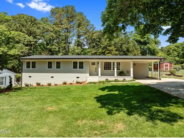 Charming home featuring a well-maintained lawn, brick facade, covered entryway, and a convenient carport at 5208 Melbourne Rd, Raleigh, NC 27606