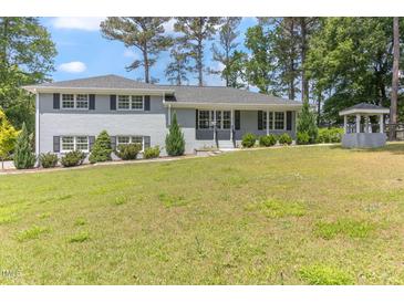 Charming light grey two-story home with a well manicured yard and mature trees at 103 Rex Pl, Louisburg, NC 27549