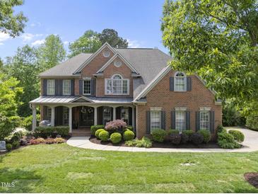 Charming brick home with a landscaped front yard and covered entryway offers classic curb appeal at 112 Roseberry Way, Holly Springs, NC 27540