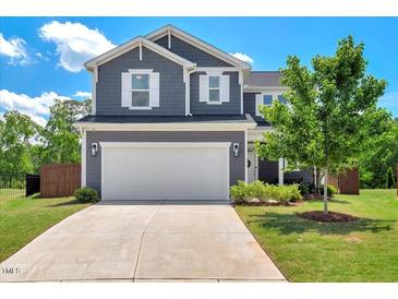 Charming two-story home featuring a two-car garage, a well-manicured lawn, and classic architectural details at 45 Iris Dr, Youngsville, NC 27596