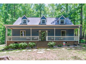 Charming home featuring a welcoming front porch, dormer windows, and lush landscaping surrounded by mature trees at 603 Gentry Ln, Hillsborough, NC 27278