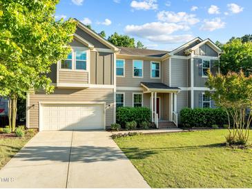Charming two-story home featuring a well-manicured lawn, attached two-car garage, and traditional architectural details at 109 Highland Mist Cir, Apex, NC 27539