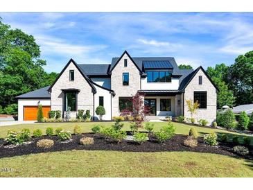 Stunning exterior of a two-story home with stone accents, black trim, and professional landscaping at 1209 Briar Patch Ln, Raleigh, NC 27615