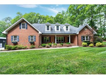 Charming brick home features a manicured lawn, flower boxes, and a welcoming front porch for relaxing outdoors at 168 E Deer, Apex, NC 27523