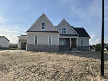Charming new two-story home featuring stone accents, inviting front porch, and a convenient attached two-car garage at 25 Deer Tail Ln # 52, Fuquay Varina, NC 27526