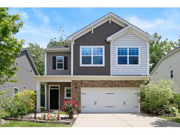 Charming two-story home featuring a stone-accented facade, two-car garage, and a beautifully landscaped front yard at 2513 Magnolia Tree Ln, Durham, NC 27703