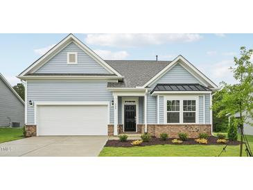 Charming home featuring light blue siding, a brick foundation, and an attached two-car garage at 529 Winding Creek Drive Dr, Lillington, NC 27546
