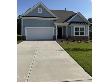 Charming single-story home with a two-car garage, manicured lawn, and inviting front porch at 529 Winding Creek Drive Dr, Lillington, NC 27546