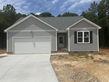 Charming exterior of a gray home with a white garage door, complemented by a well-maintained lawn and trees at 9254 Turkey Way, Middlesex, NC 27557