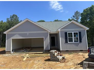 Charming single-story home with attached garage, vertical siding and blue skies above at 9254 Turkey Way, Middlesex, NC 27557